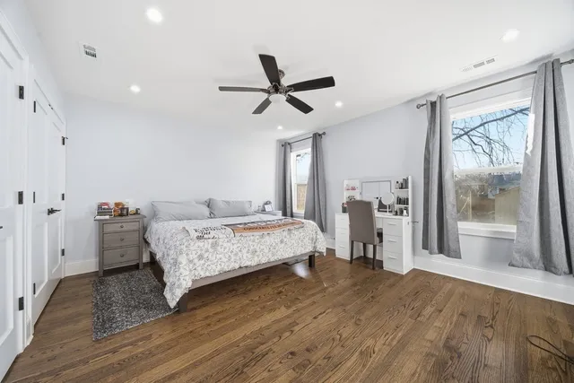 a bedroom with a bed and a large window