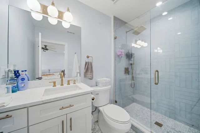 a bathroom with a sink a toilet and shower