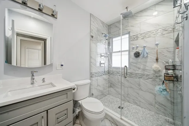 a bathroom with a sink a toilet and shower