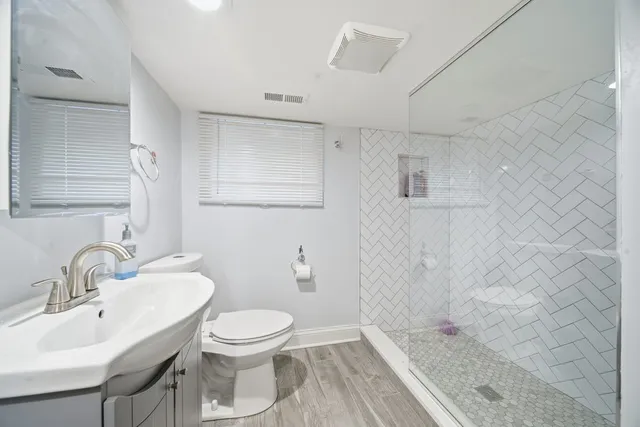 a bathroom with a sink a toilet and shower