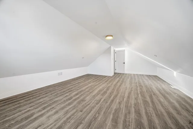 a view of a room with wooden floor and white walls