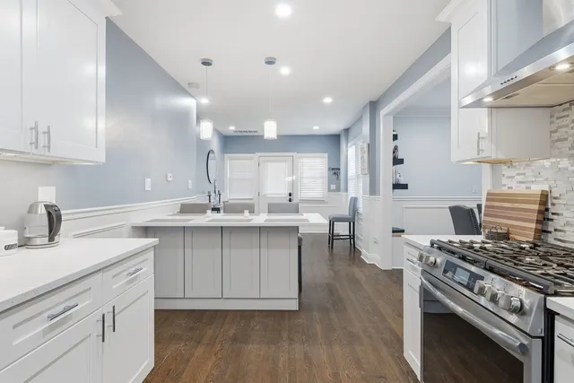 a kitchen with a sink stove top oven and cabinets