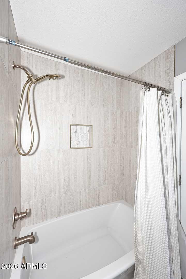 4641 East Mountain View Road Phoenix, AZ 85028 - Photo 21 of 44 a bathroom with a shower curtain and a window