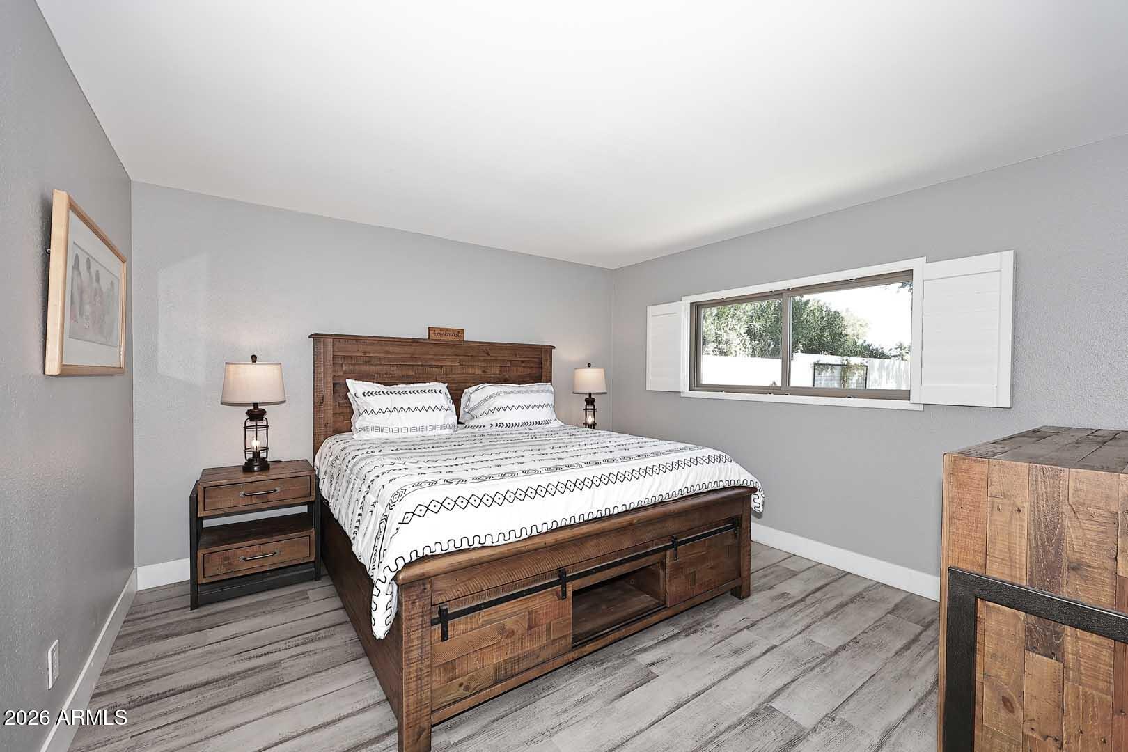 4641 East Mountain View Road Phoenix, AZ 85028 - Photo 22 of 44 a bedroom with a bed and wooden floor
