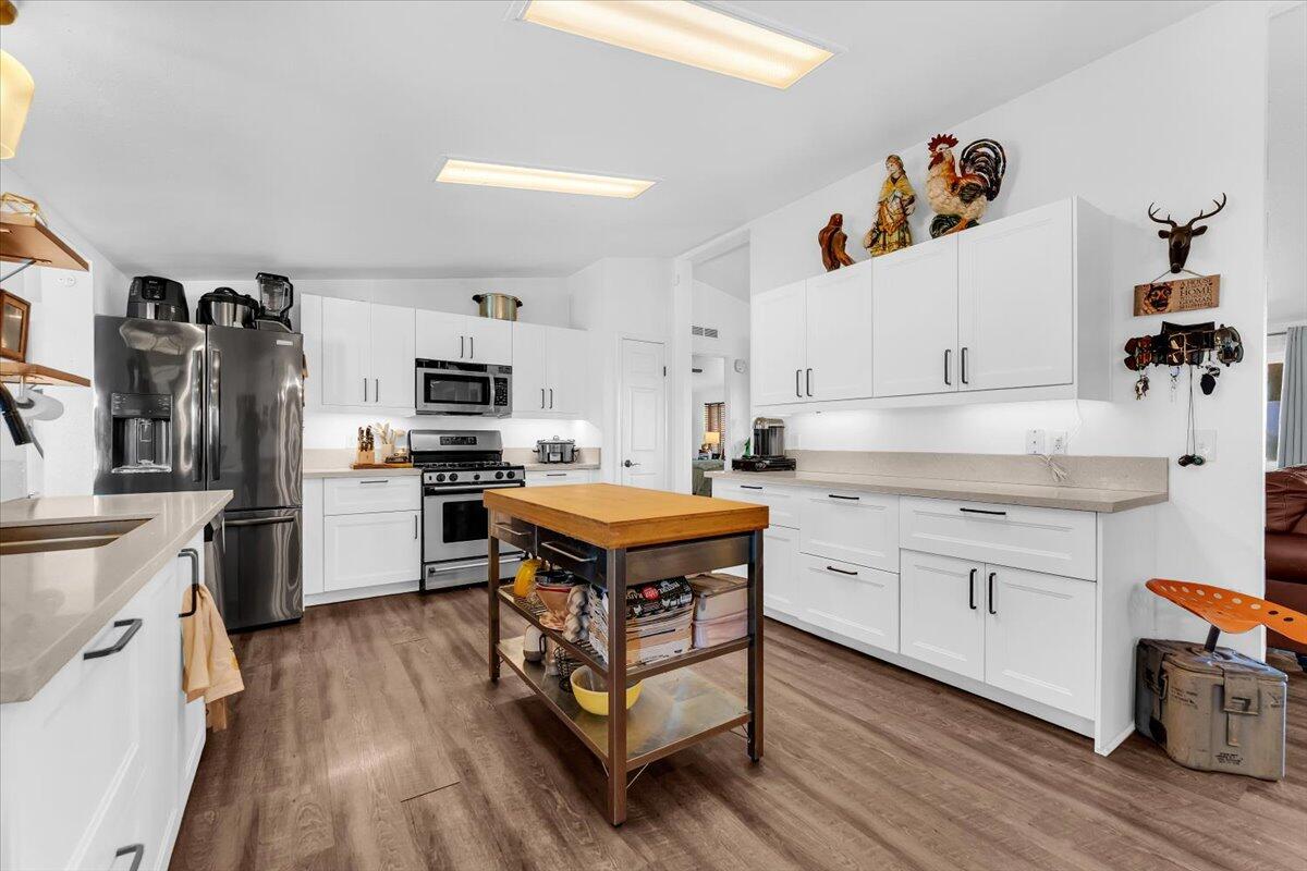 23504 Dersch Road Anderson, CA 96007 - Photo 12 of 54 a kitchen with stainless steel appliances granite countertop a stove a sink dishwasher and a refrigerator with white cabinets