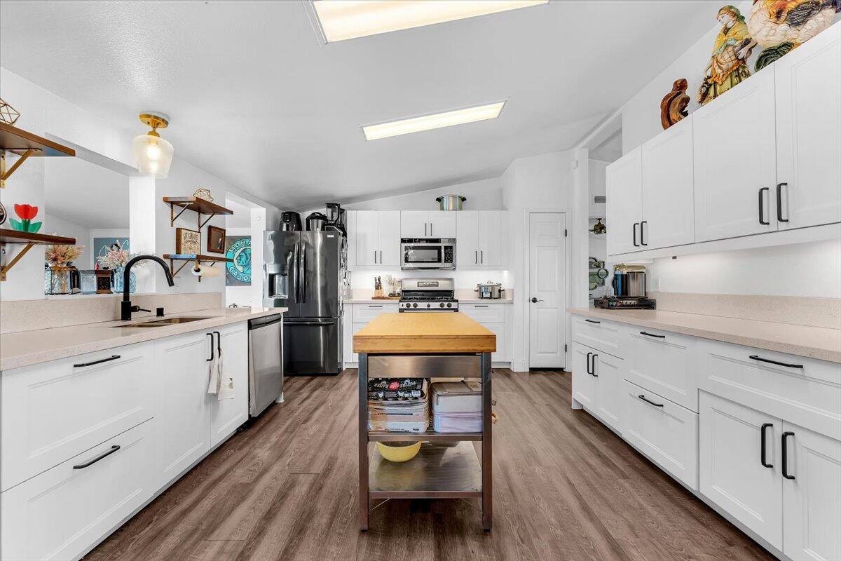 23504 Dersch Road Anderson, CA 96007 - Photo 13 of 54 a kitchen with stainless steel appliances white cabinets and wooden floor