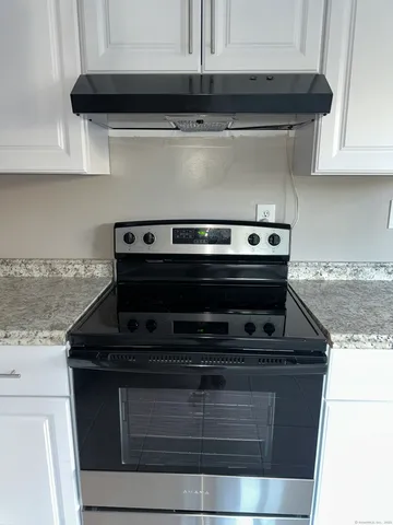 a stove top oven sitting inside of a kitchen