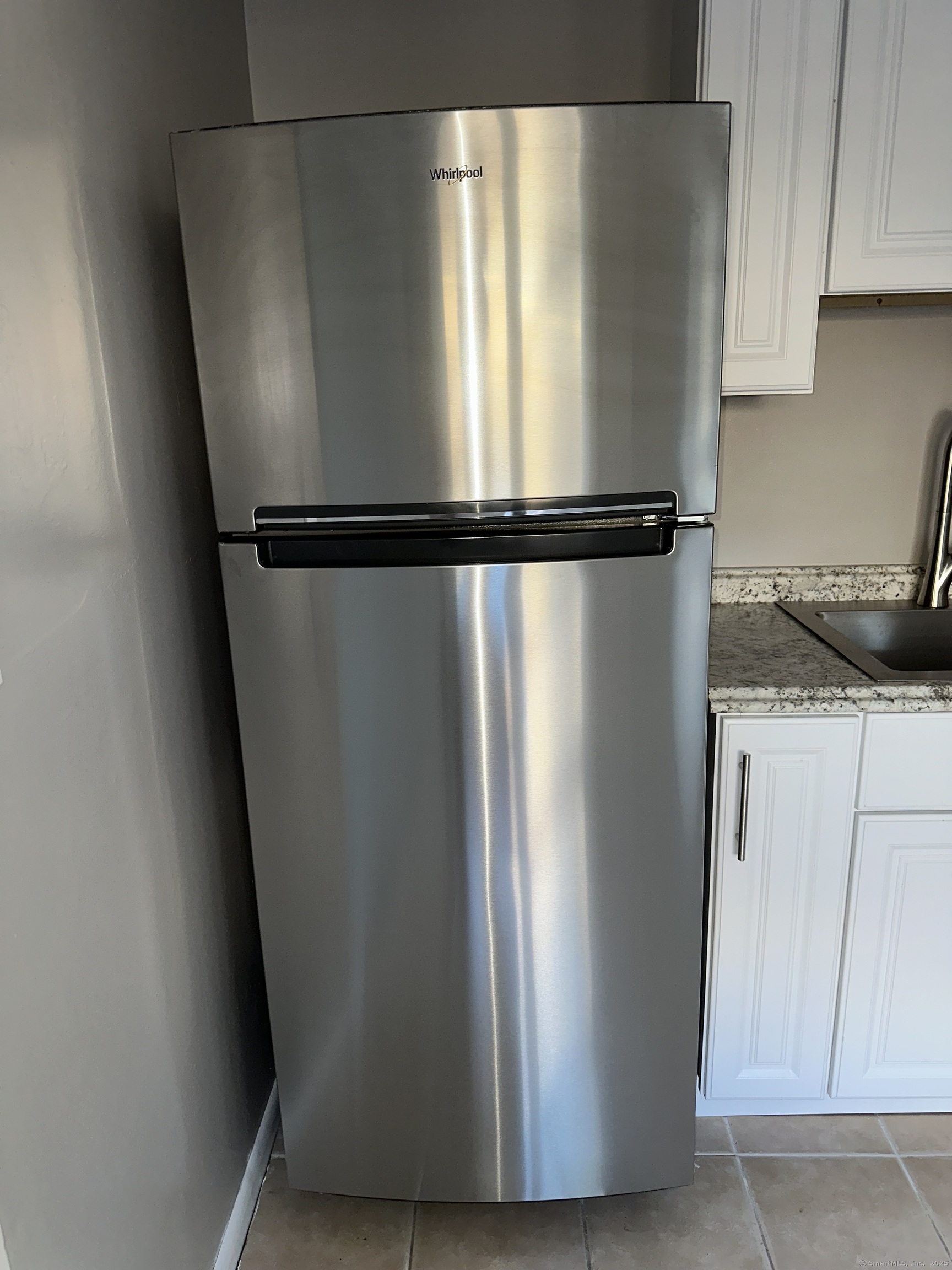 466 Merritt Street Bridgeport, CT 06606 - Photo 12 of 12 a view of a refrigerator in kitchen and white cabinets