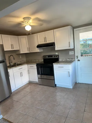 a kitchen with a stove top oven sink and cabinets