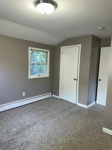 an empty room with windows and closet