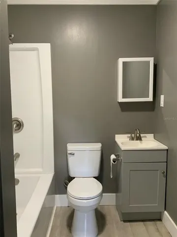 a kitchen with a sink cabinets and wooden floor