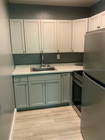 a view of a yard in front of a house with large tree