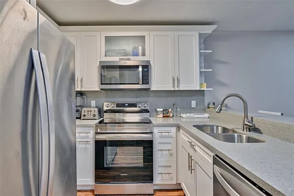 a kitchen with appliances a sink and cabinets