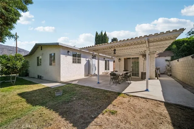 a backyard of a house with garage and a tree