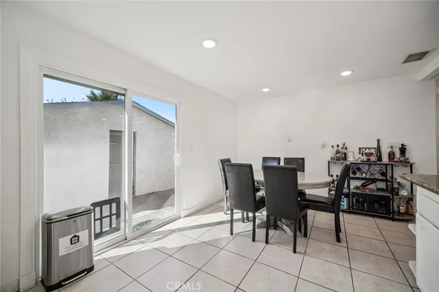 a kitchen with a dining table chairs and white appliances