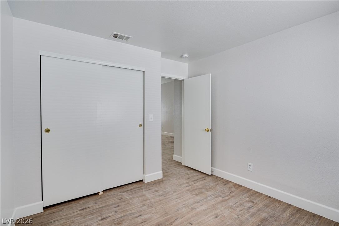 9660 Crystal Ridge Road Las Vegas, NV 89123 - Photo 7 of 13 A well-lit bedroom features durable laminate flooring and practical sliding closet doors.