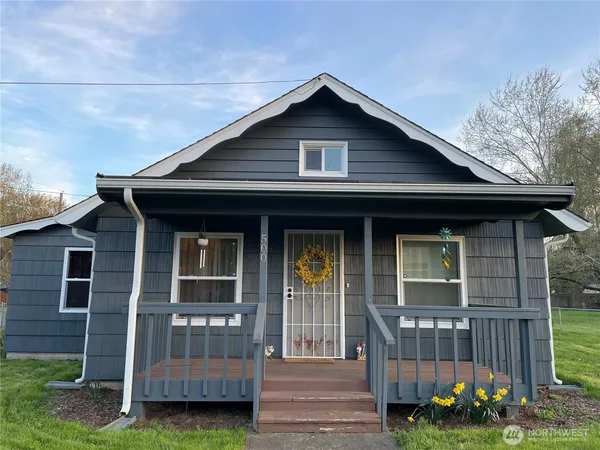 a front view of a house with a yard table and chairs