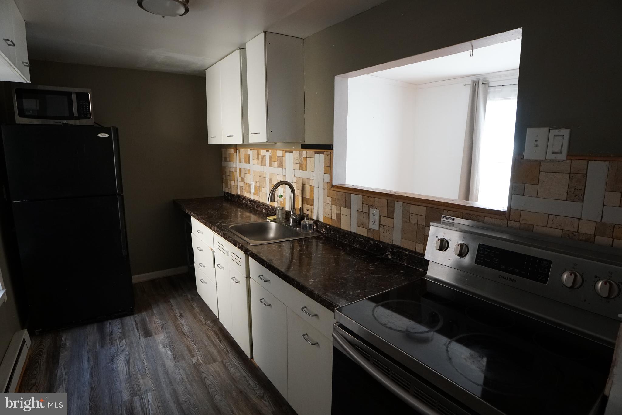 802 Cathedral Street, Unit 4 Baltimore, MD 21201 - Photo 5 of 15 a kitchen with a sink stove and cabinets