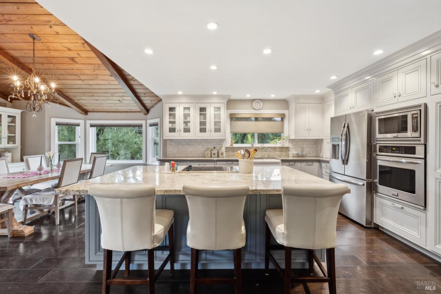 4560 Lovall Valley Loop Road Sonoma, CA 95476 - Photo 29 of 95 a dining room with stainless steel appliances kitchen island granite countertop a dining table chairs and granite counter tops