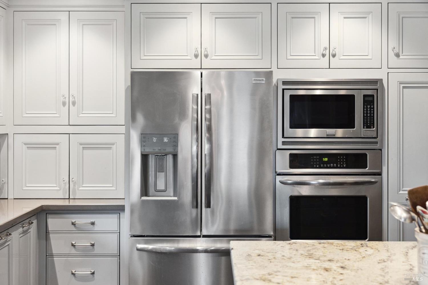 4560 Lovall Valley Loop Road Sonoma, CA 95476 - Photo 30 of 95 a kitchen with granite countertop white cabinets and stainless steel appliances