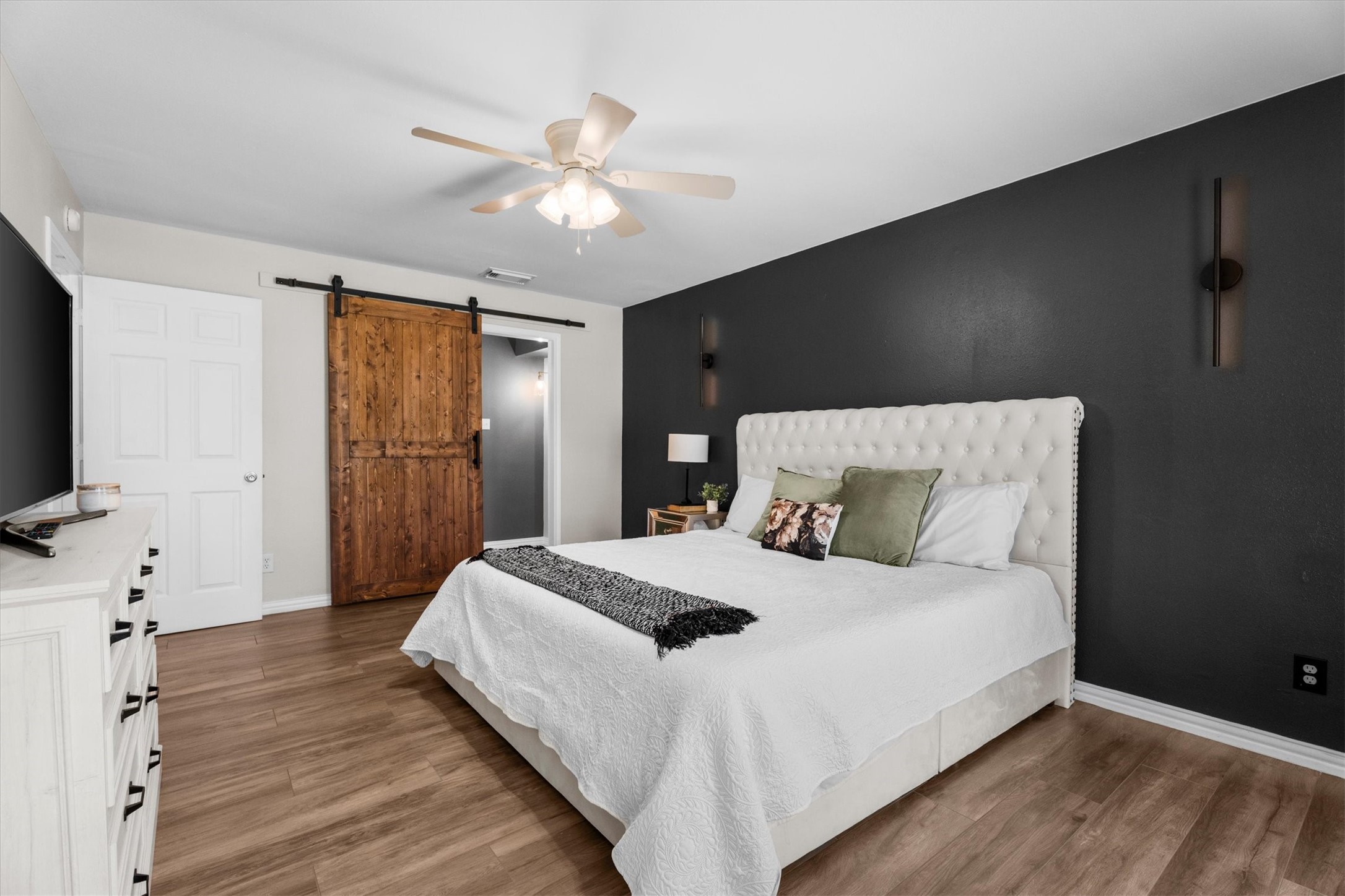 4026 Oxhill Road Spring, TX 77388 - Photo 24 of 40 A striking accent wall adds character and style, while the custom sliding barn door leads into the beautifully updated ensuite bathroom, blending modern design with everyday functionality.