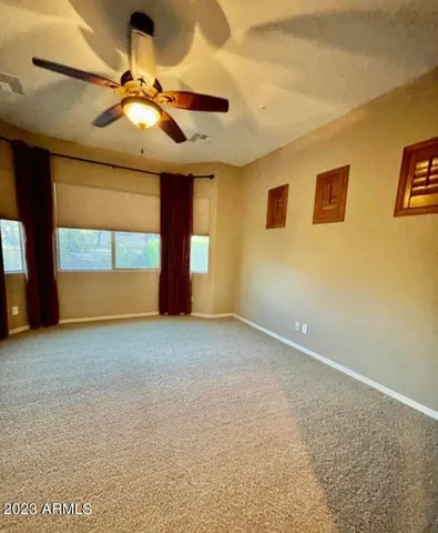 a view of a livingroom with a ceiling fan and window
