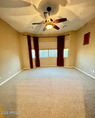 a view of a livingroom with a ceiling fan and window