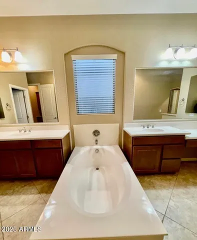 a bathroom with a tub sink and mirror