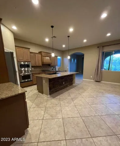 a kitchen with stainless steel appliances kitchen island granite countertop a sink and cabinets