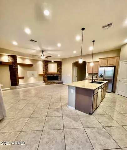 a large kitchen with a stove a sink a counter top space and cabinets