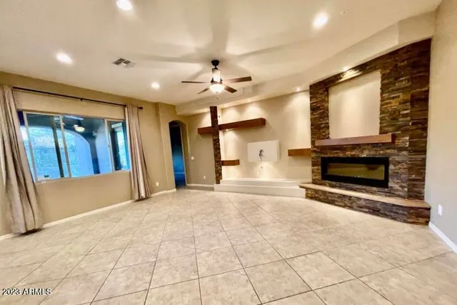 a view of an empty room with a fireplace and a window