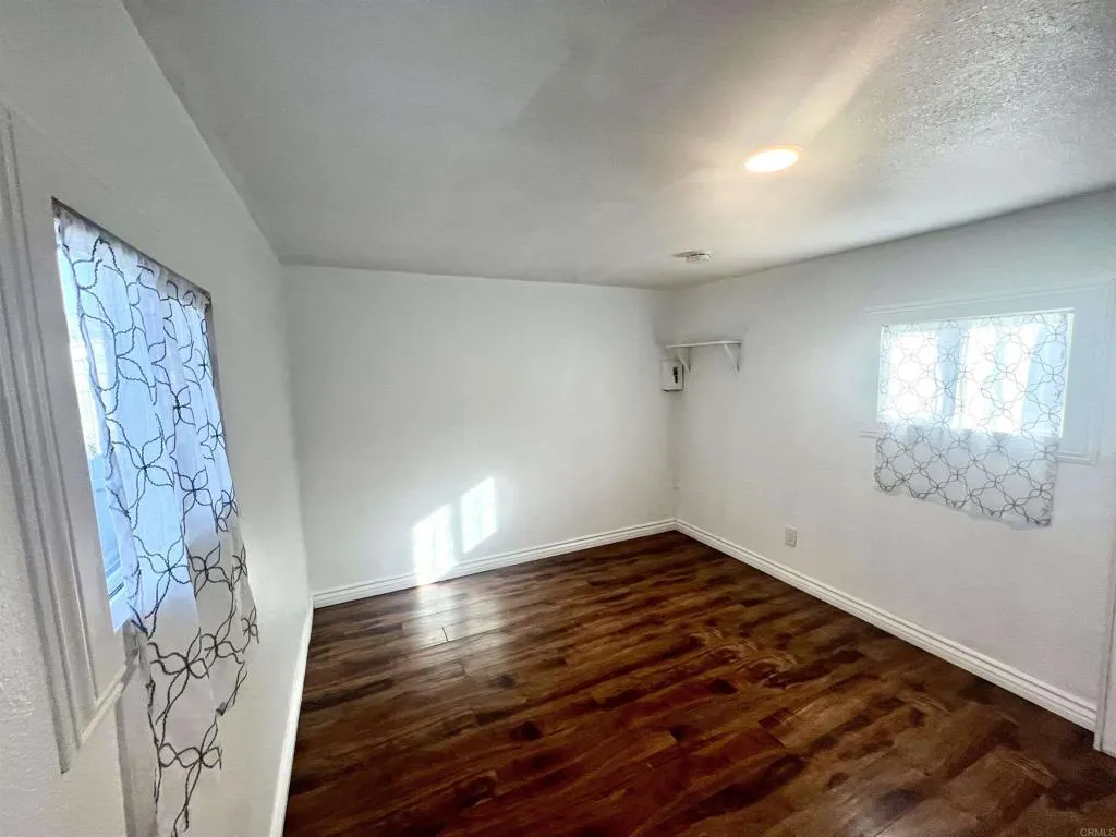 10707 Jamacha Spring Valley, Unit 72 Spring Valley, CA 91978 - Photo 11 of 18 an empty room with wooden floor and windows