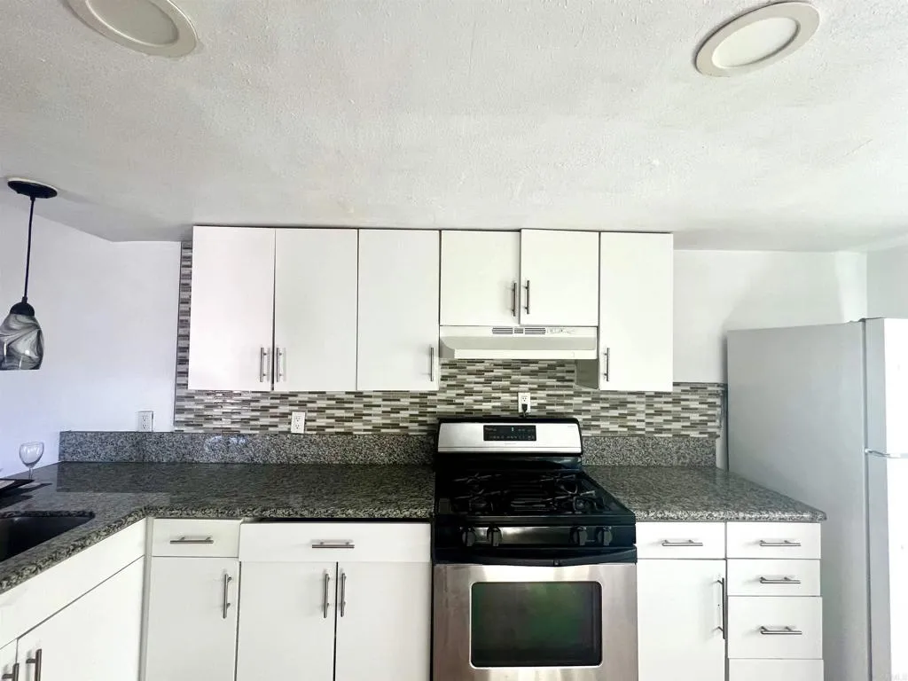 10707 Jamacha Spring Valley, Unit 72 Spring Valley, CA 91978 - Photo 18 of 18 a kitchen with granite countertop a stove a sink and a granite counter tops