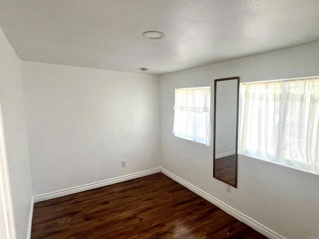10707 Jamacha Spring Valley, Unit 72 Spring Valley, CA 91978 - Photo 9 of 18 an empty room with wooden floor and windows
