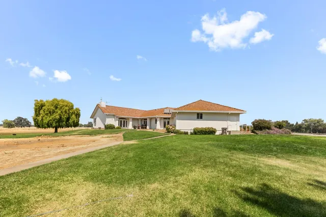 a front view of a house with a garden and yard
