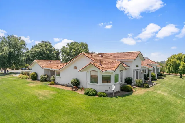a front view of a house with a yard and outdoor seating