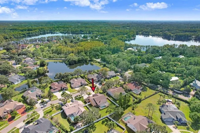 an aerial view of residential houses with outdoor space and trees