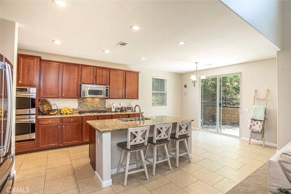 17122 Broken Rock Court Riverside, CA 92503 - Photo 12 of 61 a kitchen with stainless steel appliances granite countertop a stove top oven a sink a counter top space and cabinets