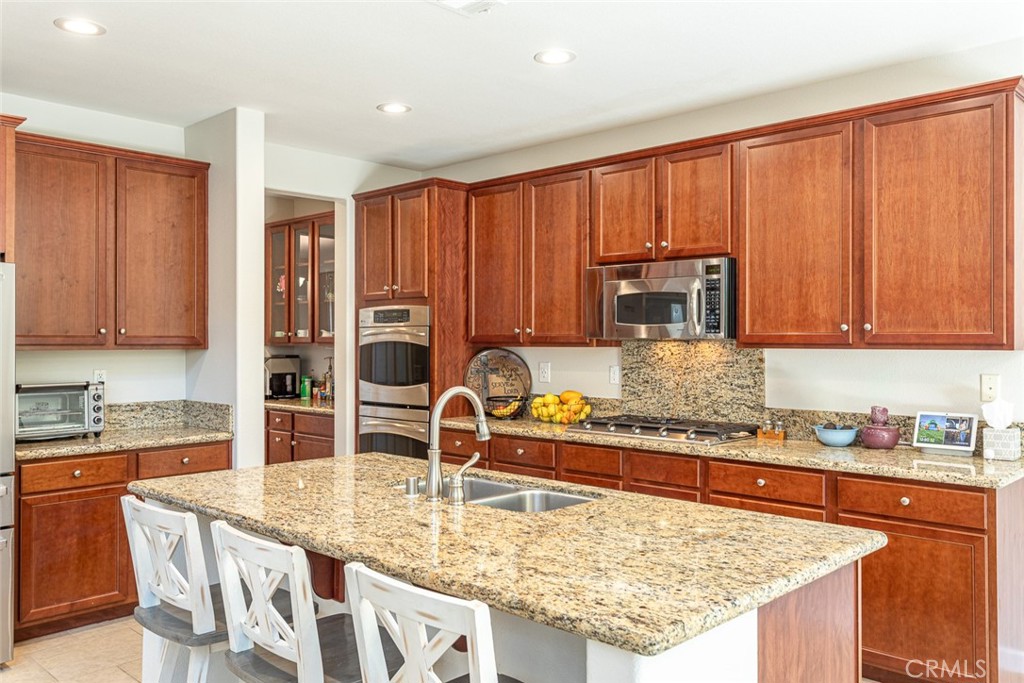 17122 Broken Rock Court Riverside, CA 92503 - Photo 17 of 61 a kitchen with granite countertop a sink a stove and cabinets