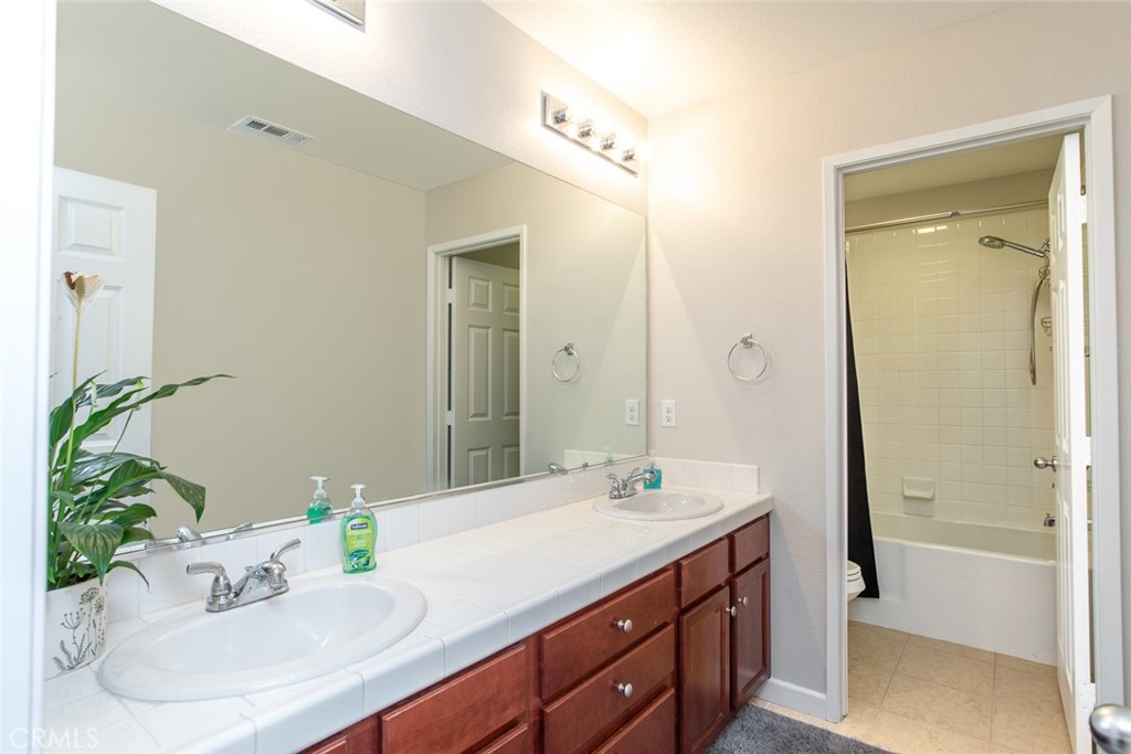 17122 Broken Rock Court Riverside, CA 92503 - Photo 29 of 61 a bathroom with a granite countertop sink and a mirror