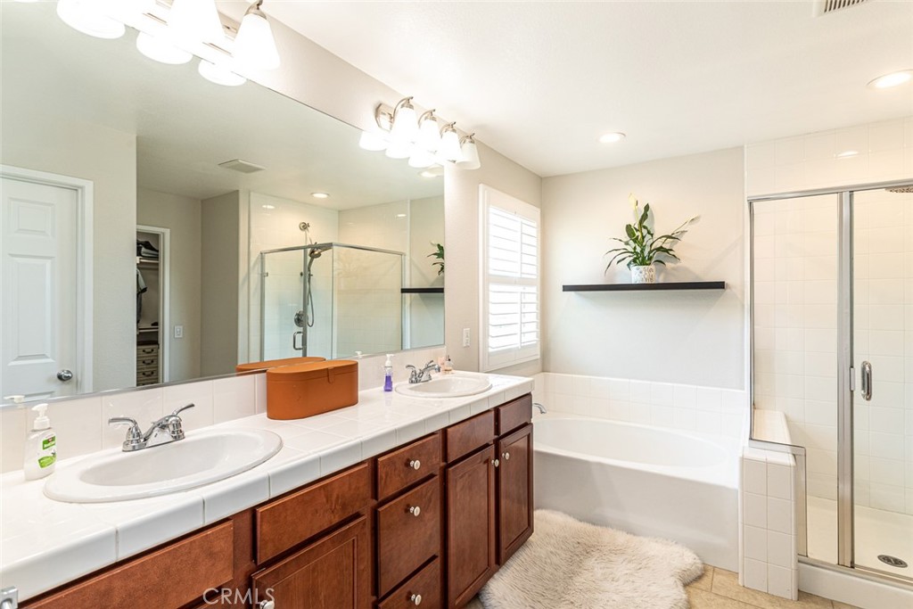 17122 Broken Rock Court Riverside, CA 92503 - Photo 36 of 61 a bathroom with a tub a sink and mirror