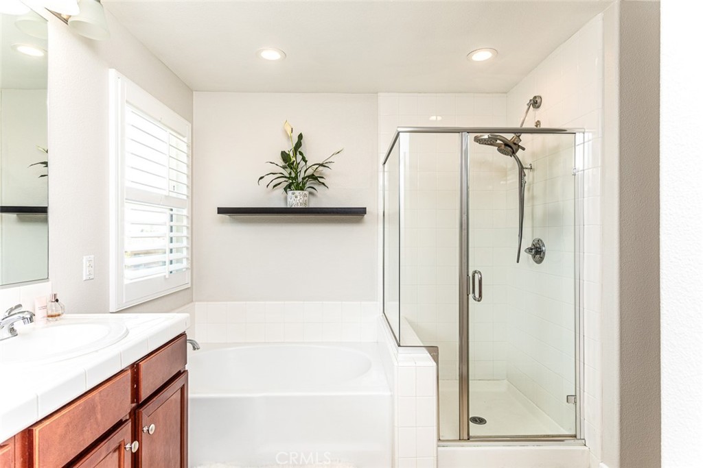 17122 Broken Rock Court Riverside, CA 92503 - Photo 37 of 61 a bathroom with a granite countertop sink a shower and a mirror