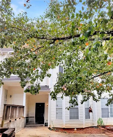 a front view of a house with a tree