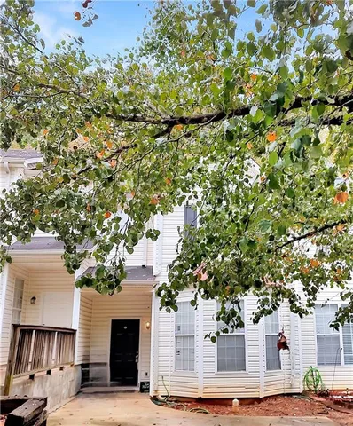 a front view of a house with a tree
