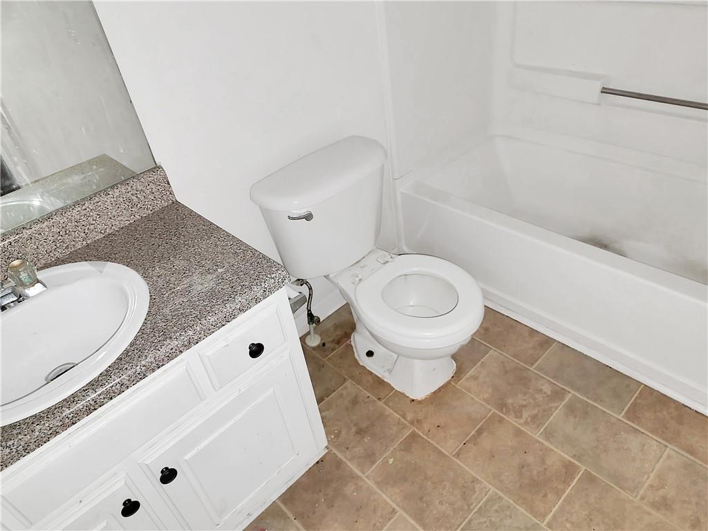 6710 Sunset Hills Boulevard Rex, GA 30273 - Photo 11 of 12 a bathroom with a granite countertop sink mirror vanity and toilet