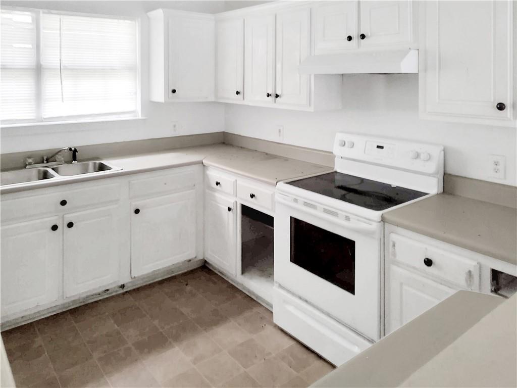6710 Sunset Hills Boulevard Rex, GA 30273 - Photo 5 of 12 a kitchen with granite countertop white cabinets and white appliances