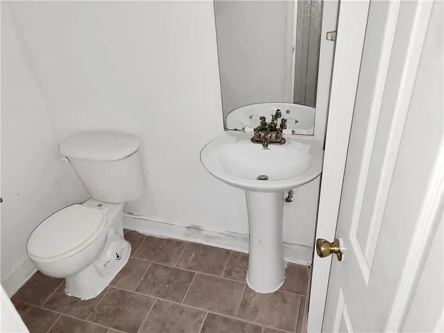 a bathroom with a toilet sink and mirror