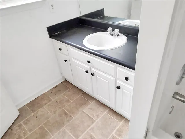 a bathroom with a sink vanity and a mirror