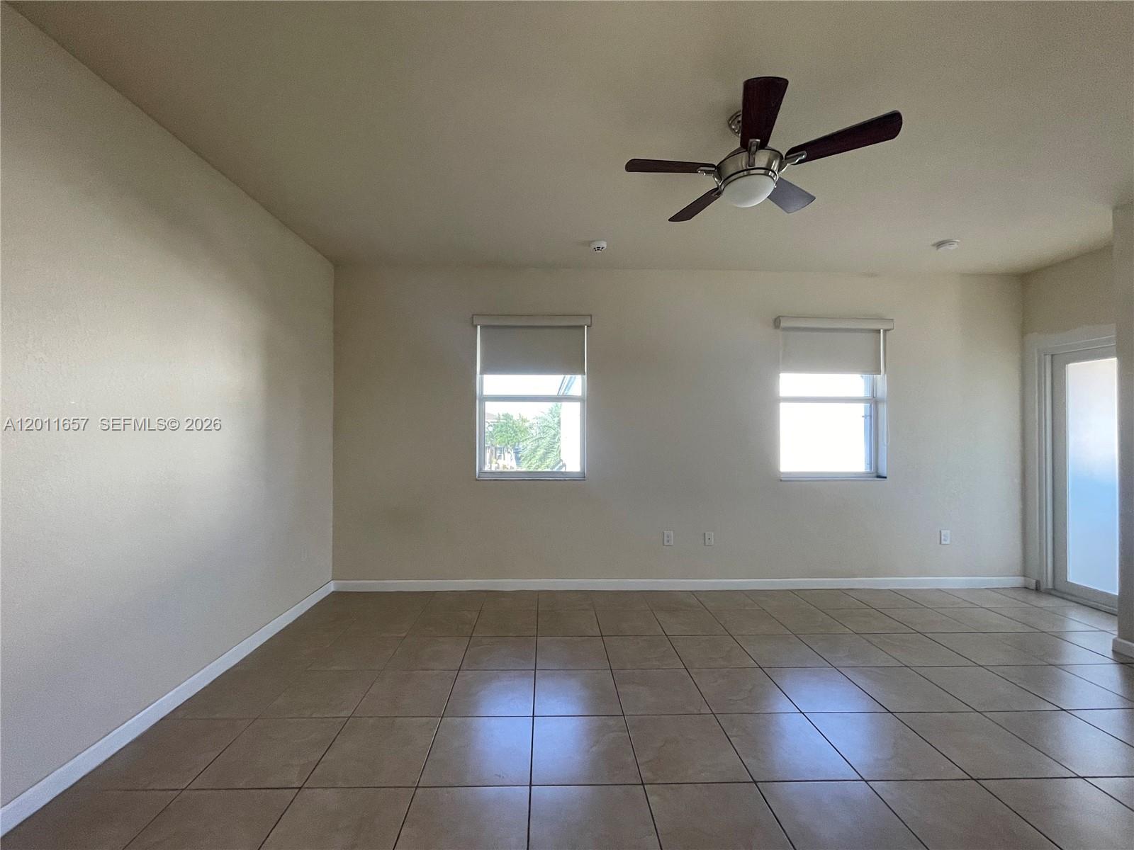 9262 Southwest 171st Court, Unit A Miami, FL 33196 - Photo 4 of 7 a view of a livingroom with a ceiling fan and window