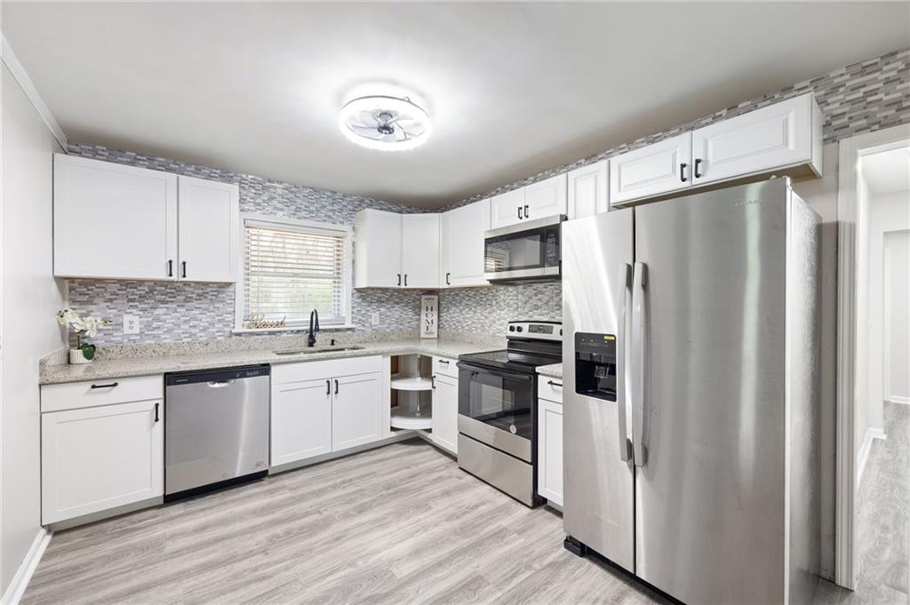 4611 Old Westside Road Austell, GA 30106 - Photo 12 of 37 a kitchen with white cabinets and stainless steel appliances